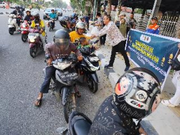 Ketua PWI Riau Raja' Isyam Azwar membagikan makanan berbuka kepada masyarakat yang melintasi Jalan Gajah Mada, Sabtu (23/3/2024). (humaspwiriau)