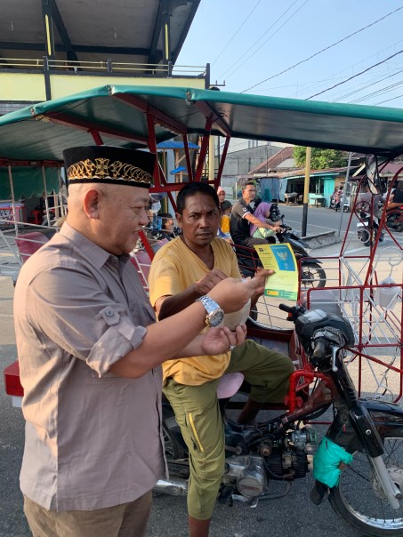 Kepala Kantor Imigrasi Selatpanjang, Azhar SH MH membagikan takjil gratis kepada pengendara beca motor dan juga mensosialisasikan E-Paspor melalui pembagian brosur, Jum'at (22/3/2024)