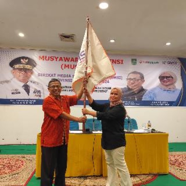 Luna Agustin menerima bendera pataka yang diserahkan Waketum SMSI Pusat Yono Hartono. (istimewa)