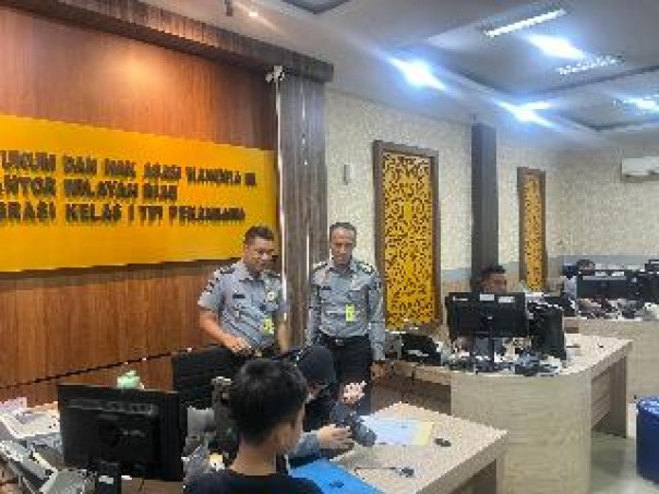 Kepala Seksi Humas Kantor Imigrasi Kelas I TPI Pekanbaru, Baharuddin,memantau proses pembuatan paspor, Selasa (24/12/2024). (istimewa)